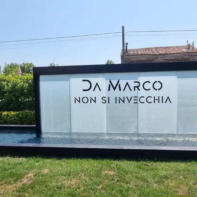 Scritta traforata DA MARCO sulla parete d'acqua della fontana in giardino