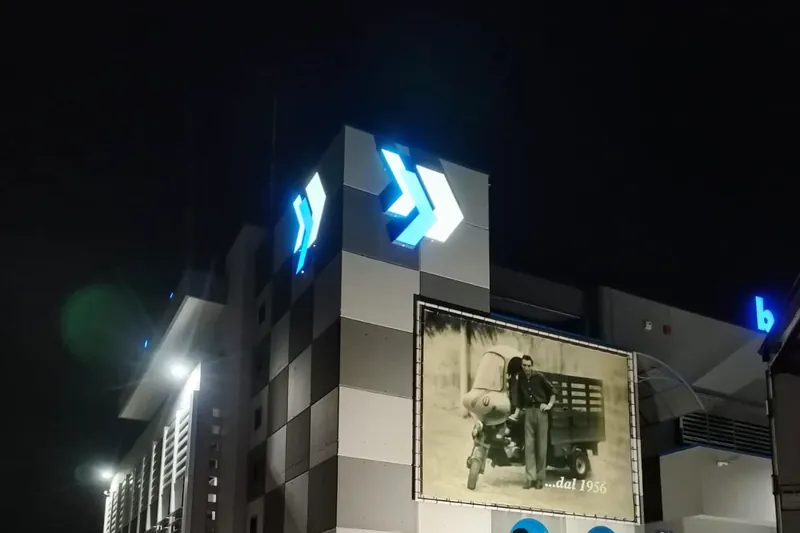 Loghi luminosi blu e telo stampato su una facciata, di notte