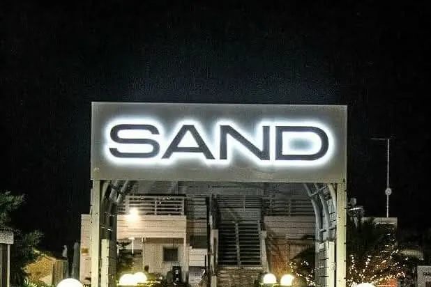 Lettere retroilluminate SAND sul portale d'ingresso, di notte